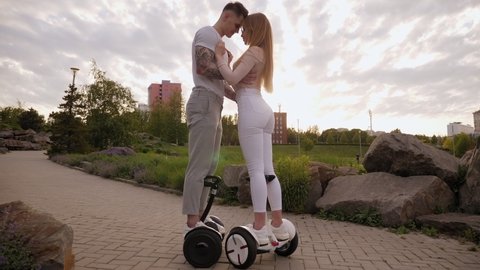 Happy man and woman riding on the hoverboard. Active lifestyle. Summer vacation.