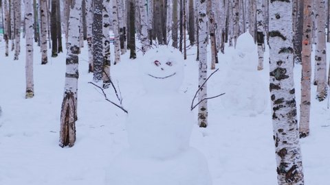 Close-up of a real snowman made of snow in a winter forest