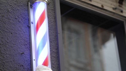 A barber's pole, unusual symbol of barbershops - a small column of blue-white-red tricolor.