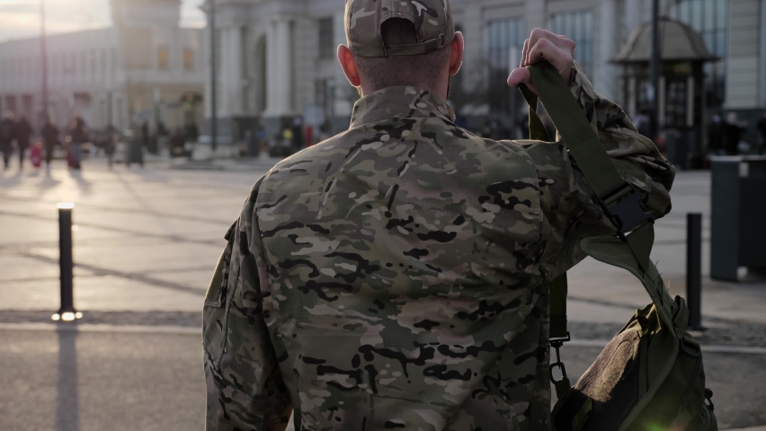 Back view of male soldier leaving on military service. Man in military uniform putting bag on shoulder and walking to railway station. Concept of military service, army, duty Royalty-Free Stock Footage #1064909887