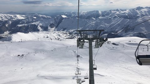 Panoramic View down from chair lifts with slope and beautiful mountains background.Ski holidays in Gudauri,Georgia