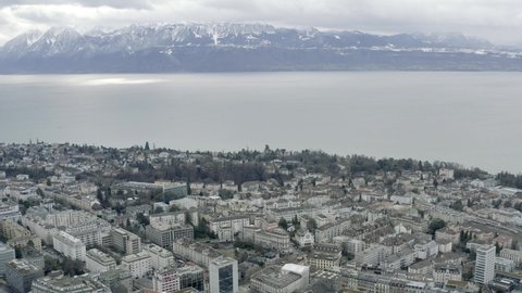 Drone Aerial of Lausanne located at the lake geneva in winter during the holiday season. The scenic lac lehman shows reveals the mountain landscape on the french side of the lake. Switzerland, Europe.