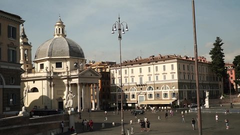 Rome - July 7, 2019: Time lapse view of the famous Roman square Piazza del Popolo with a gathering of numerous tourists and twin churches in the background, on a sunny day