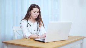 Woman doctor talking to client using virtual chat computer app. Female medical assistant wears white coat, video calling distant patient on laptop. Telemedicine, online remote healthcare services
