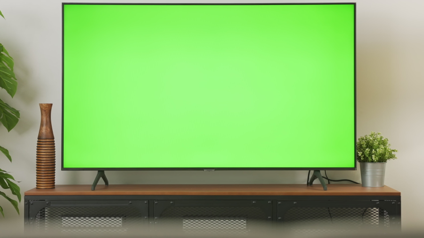Zoom out shot of TV Green Screen in living room with tree and lamps. chroma key screen for advertising. | Shutterstock HD Video #1064948368