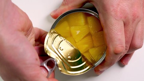 opening a can of pineapple Metallic can with pineapples opened
