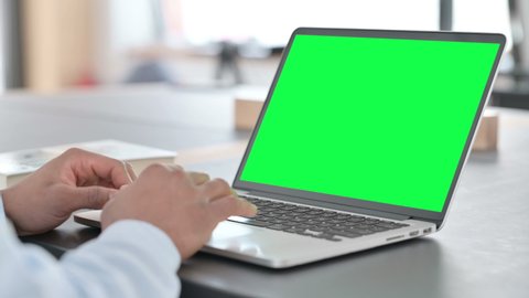African Man Typing on Laptop with Green Chroma Key Screen