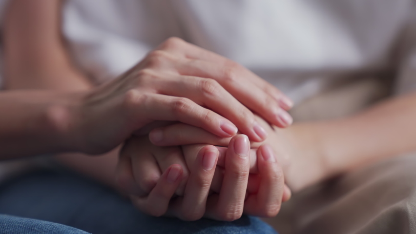 Close-up shot of two people holding hands for encouragement. | Shutterstock HD Video #1064954221