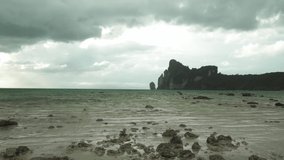 The tide saw coral remains on the beach. Strong winds and waves, Dark big cloudy coming before the rain at Phi Phi Island, Thailand  