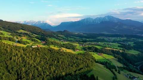 Green meadows, alpine houses and mountain peaks, Salzburger area, Austria.