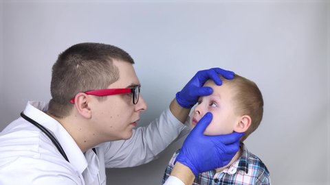 An ophthalmologist examines a boy who complains of burning and pain in his eyes. Eye fatigue from a computer or phone screen (sensation of sand on the cornea). Diagnosis of conjunctivitis in children.