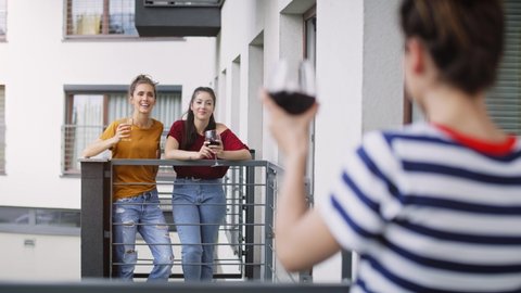 Handheld video of three friends having home party on balcony. Shot with RED helium camera in 8K