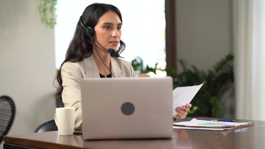 young operator woman working with headset and laptop computer in a call centre . customer service help desk online . 