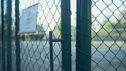 Prohibited enter sign on metal fence of sport playground during coronavirus pandemic. Concept lockdown in sport industry.