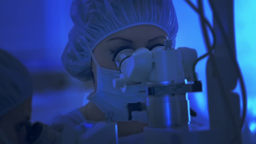 Doctors looks through a microscope during surgery, microsurgery, CINEMATIC BLUE | Shutterstock HD Video #10649849
