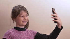 young girl has fun making selfies with mobile phone at home