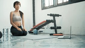 Strong beautiful fitness Young asian woman doing plank exercise and using laptop for digital workout sessions at home, Online training.