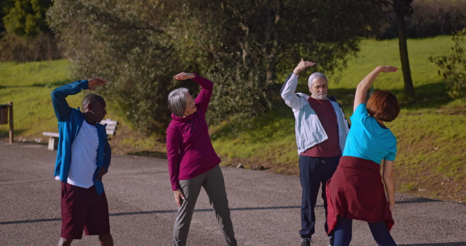 Senior group of friends stretching and exercising on oudoors park