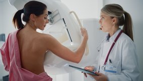 Friendly Female Doctor with Tablet Computer Explains Mammogram Procedure to a Topless Adult Female Patient Undergoing Mammography Scan. Healthy Woman Does Cancer Prevention Routine in Hospital Room. - Powered by Shutterstock - Get 15% off with code: PIKWIZARD15