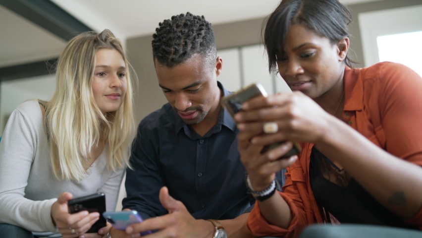 Multicultural group of friends looking at smartphones, a Person Video by goodluz