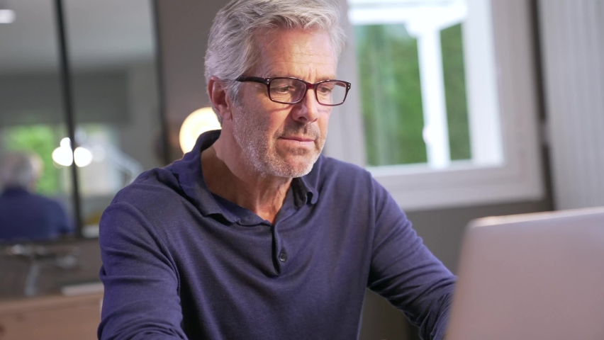 Portrait of senior man with grey hair connected with laptop Royalty-Free Stock Footage #1065008041