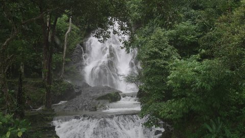 4K of beautiful Punyaban waterfall cascades from the summit during the monsoon season at Ranong the south of Thailand.