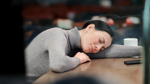 Upset young asian woman feeling pain crying lying on table at public cafeteria having bad news. Depressive female with broken heart worried about problem suffering from betrayal. 4k  camera