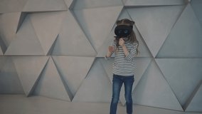 Child using a VR headset enjoying a video or interactive game. Little girl with virtual reality glasses.