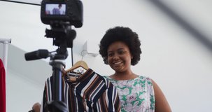 African american female plus size vlogger recording a video about fashion. self isolation technology communication at home during coronavirus covid 19 pandemic.