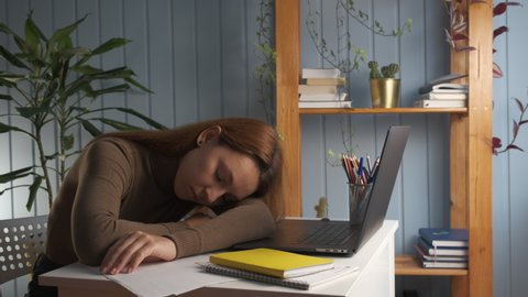 Young woman sleeping at desk with laptop and papers feels tired. Unmotivated unproductive employee woman lying on table fall asleep feeling boredom. Need rest, no energy, insomnia concept