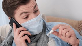 A man holding a thermometer and making a call to a doctor. - Powered by Shutterstock - Get 15% off with code: PIKWIZARD15