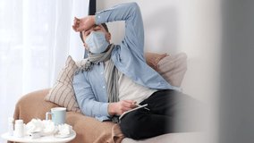 A man who is self-isolated and working from home because of a massive pandemic. A man holding a thermometer to measure body temperature. - Powered by Shutterstock - Get 15% off with code: PIKWIZARD15