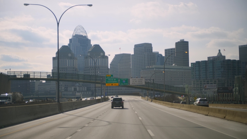 4k Slow Motion of Car Passenger POV Point of View Entering Downtown Cincinnati, Ohio on Highway Interstate and Moving Towards Buildings, Traffic, Skyscrapers, and Infrastructure