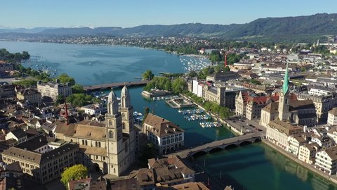 Aerial drone footage of the famous Zurich old town along the Limmat river and lake Zurich on a sunny summer day in Switzerland largest city. 