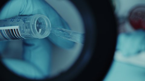 Footage in Magnifying Glass of a Hand in Glove Applying Chemical Liquid with Micro Pipette in a Sample Tube. Innovative Science Laboratory with Modern Medical Equipment for Genetics Research.
