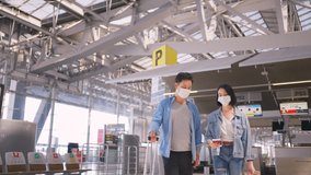 Man and woman passengers wearing face mask walking in airport terminal to boarding gate during the COVID pandemic to prevent coronavirus infection. New normal lifestyle in air transport concept. - Powered by Shutterstock - Get 15% off with code: PIKWIZARD15