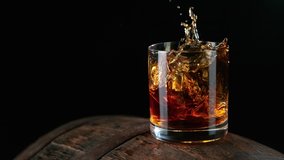 Ice dropped into glass of whisky on barrel in super slow motion. Shot with high speed cinema camera, 1000fps. - Powered by Shutterstock - Get 15% off with code: PIKWIZARD15