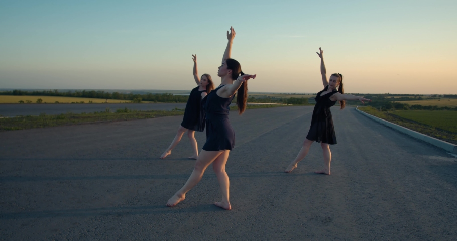 Young women spinning, doing dancing moves outdoors in the morning, film grain 4k