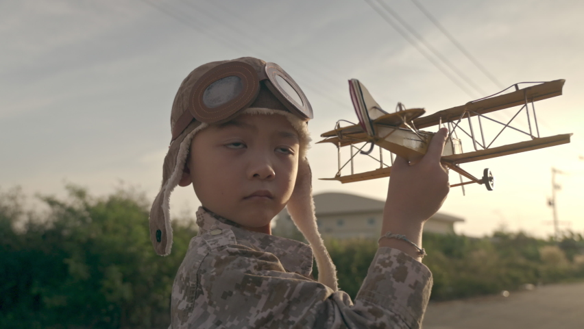the boy plaing the tiny airplane during sunrise. the concept of inspiration, ambition, imagination, education and future