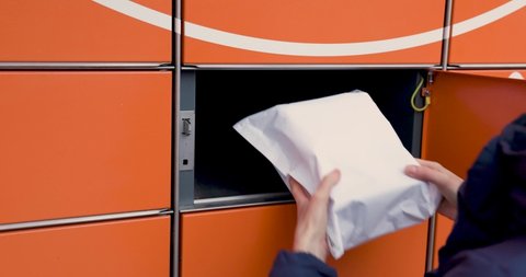 receive parcel from self service post terminal machine. hand open locker and taking out package