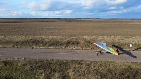 Hang glider wing launches from the runway in the fields. Dangerous hobby