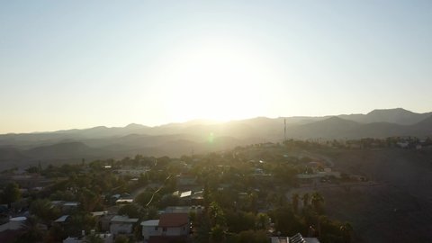 Small village in the desert at sunset, aerial view
drone view Palm trees Mountains and red rofftops,vered yericho, Israel
