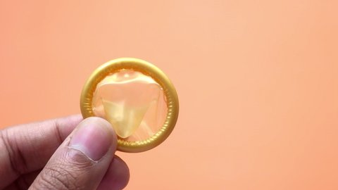 close up of condom on orange backgrund 
