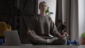 woman doing yoga exercises at home and watching lessons on the internet