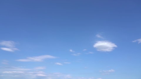 Beautiful sunny clear blue sky with soft fluffy white clouds flying calmly in heaven. Video time lapse