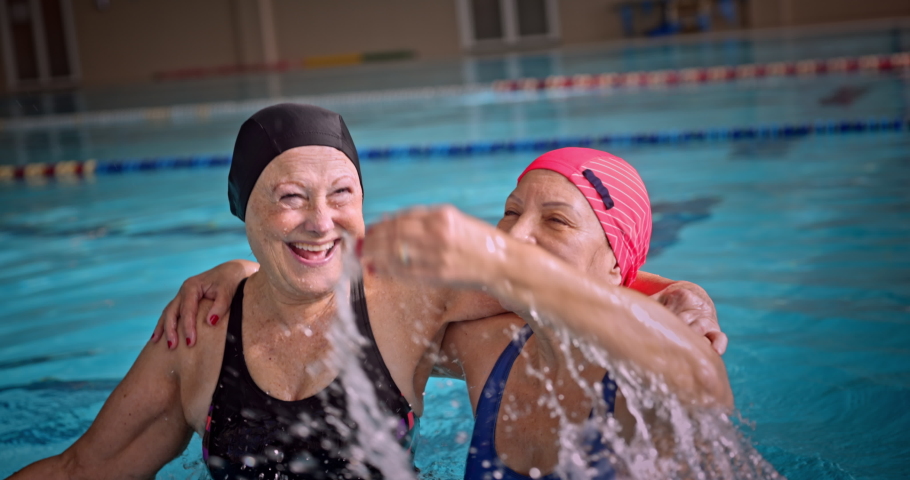 Senior women jumping splashing water having fun in indoor pool | Shutterstock HD Video #1065105481