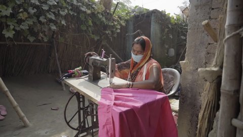 Champaran, Bihar, India, November 17 2020, In Champaran district of Bihar, A Poor Indian woman wearing face mask, working on sewing machine. High quality 4k footage