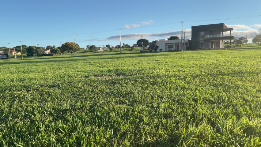 
house in quiet location with green grass, blue sky in the middle of the afternoon and lens flare