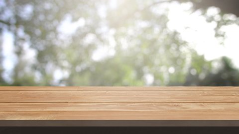 Top wood table on outdoor garden. Top wood space area for products show. Nature tree blur background. Wood table and product show concept.