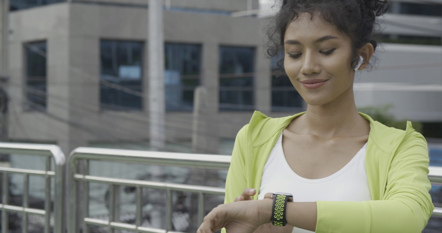 Sport girl using smartwatch when she exercise with smiling. Healthcare, Sport and Technology concept.